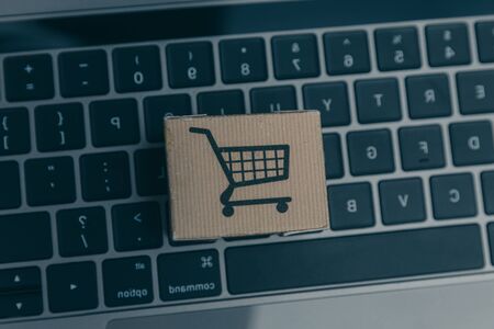 Laptop and small cart on white background. Internet shopping concept.の写真素材