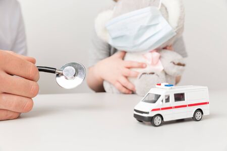 Doctor and kid sitting in the cabinet with ambulance.の写真素材