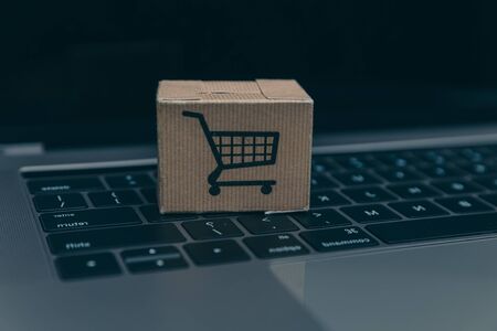Laptop and small cart on white background. Internet shopping concept.の写真素材