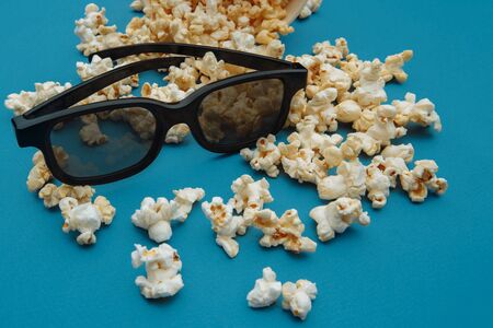 Popcorn and 3d glasses on blue background. Entetainement conceptの写真素材