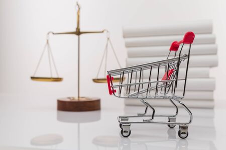 Shopping trolley and symbol of law and justice. Consumer rights concept. Regulations, restrictions, prohibition.の写真素材