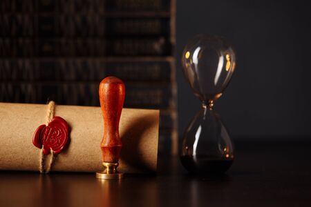 Wooden gavel, hourglass and stamp on testament and last will on wooden table. Notary public tools close-upの写真素材