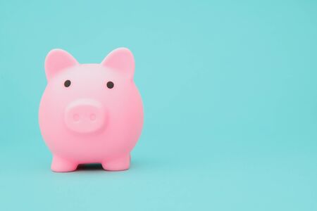 Savings concept. Moneybox in shape of pig on blue background space for text.の写真素材