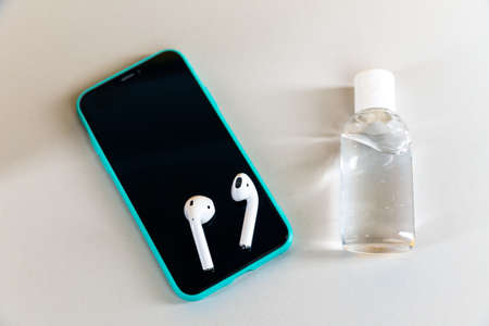 Tula Russia 13.04.2020 Phone with airpods on the desk isolated.のeditorial素材