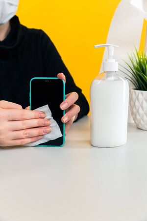 Desinfecting phone concept. Woman cleaning mobile.の写真素材