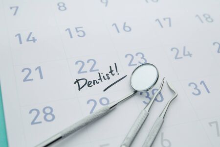 Dental health and teethcare concept. Dentist appointment in calendar and professional dental tools.の写真素材