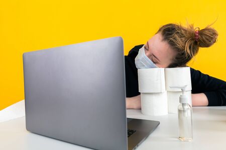 Working on quarantine at home. Woman at the desk with laptop and toilet paper.