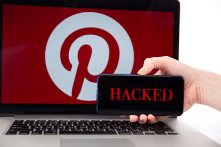 Tula Russia 12.02.2020 Hacked Pinterest on the phone and laptop conceptのeditorial素材