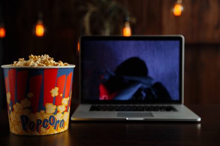 Have a good evening watching a movie on a laptop with popcornの写真素材
