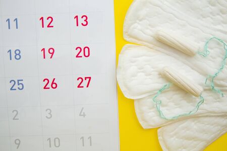 Menstruation calendar with menstrual tampons and pads. Woman critical days, woman hygiene protection conceptの写真素材