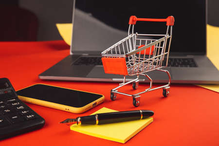 Online shopping concept with cart and smartphone with laptop. Ecommerce market. Transportation...