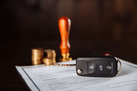 Contract form for car loan, stamp, pen and car key on wooden tableの写真素材
