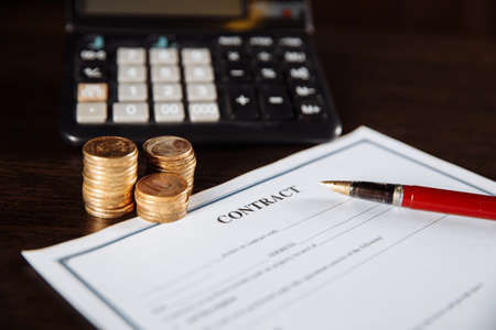 Signing a contract, points and coins next to the calculator