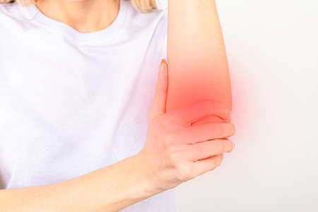 Woman suffering from chronic joint rheumatism. Elbow pain and treatment concept.の写真素材