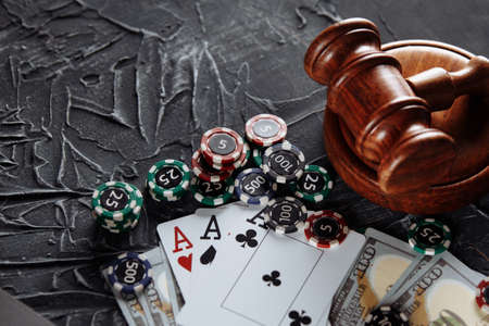 Concept of legal regulation of gambling, justice gavel on the background of an old grey table