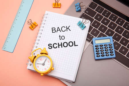 School office supplies on pink background and notebook with BACK TO SCHOOLの写真素材