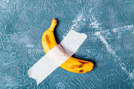 Taped banana on the wall as an art object. Minimalism concept.の写真素材
