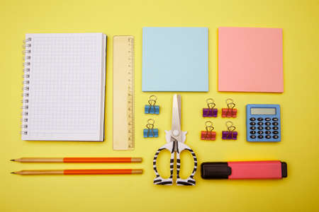 School supplies on yellow background. Back to school abstract background. Creative flat lay with...