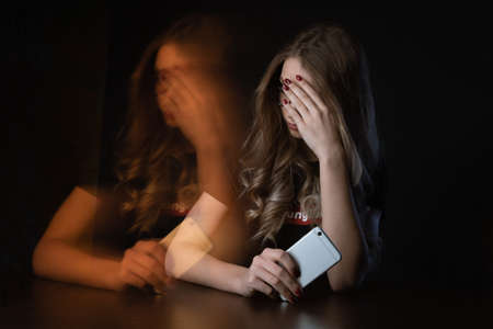 Closeup picture of frustrated girl, young woman being a victim of bullying onlineの写真素材
