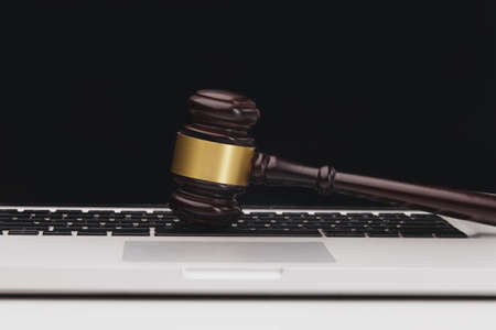 Wooden judge hammer on laptop computer white keyboardの写真素材