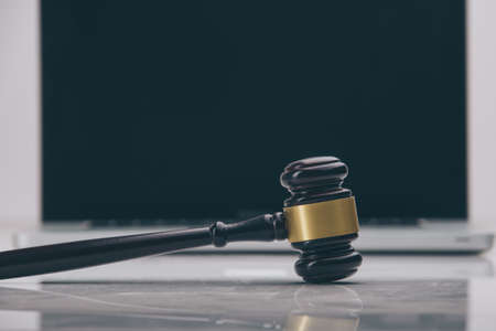 Closeup of laptop and mallet on table in courtroomの写真素材