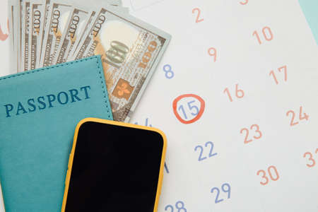 Travel, tourism, holiday concept. Calendar with passport and smartphone on blue background