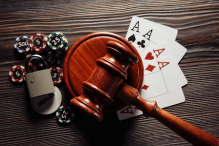 Judges wooden gavel, poker chips and playing cards on wooden table. Concept of Law and regulation of gamblingの写真素材