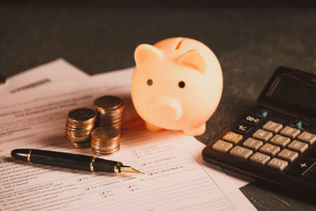 Close up woman hand using calculator and writing make note with calculate about cost at home office.