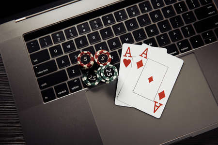 Online poker casino theme. Gambling chips and playing cards on keyboardの写真素材