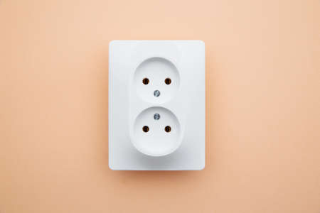 White plastic power socket on pink background. Top view