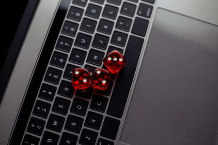 Online casino theme. Red dices on keyboard