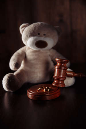 Divorce concept. Wooden gavel, rings and teddy bear as symbol of child. Family lawの写真素材
