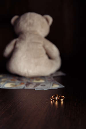 Dollar banknotes, rings and teddy bear close-up. Divorce, separation and alimony conceptの写真素材