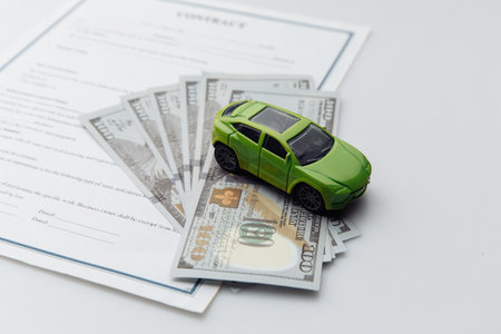 Toy car and contract on a white table. Car purcase conceptの写真素材