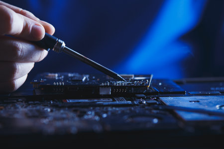 hardware maintenance and repair. electronics and computer components renovation. engineer soldering broken motherboardの写真素材