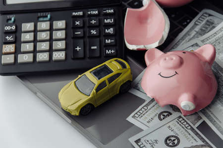 Yellow car and dollars bills with broken piggy bank. Insurance concept