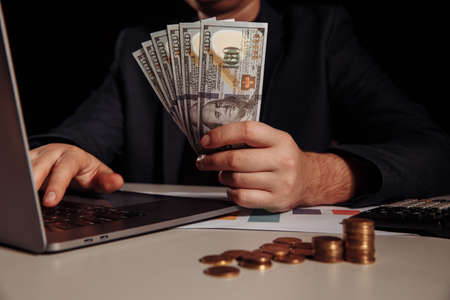Businessman earn a lot of money from internet online by only using laptop. Investment concept