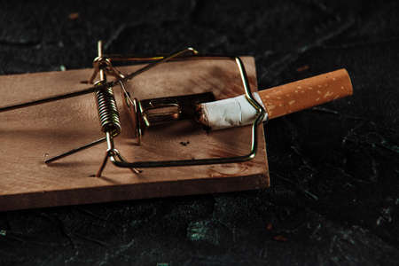 Cigarette on a mouse trap close-up. Dangerous habbit conceptの写真素材