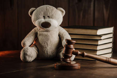 Divorce and alimony concept. Wooden gavel and teddy bear as symbol of child on a deskの写真素材