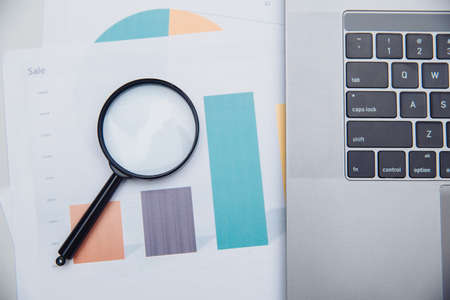 Laptop, charts and magnifying glass. Business conceptの写真素材