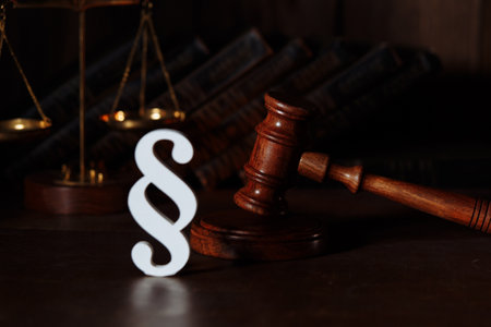 Scales, judge gavel and white paragraph sign in a courtroomの写真素材
