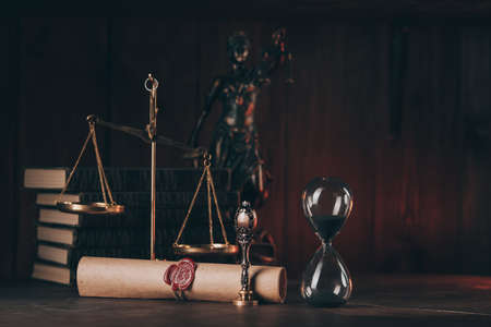 Hourglass, books and stamp on testament and last will in dark roomの写真素材