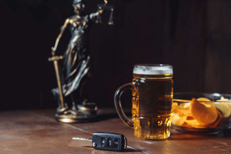 Drunk driving concept. Lady of justice, glass of beer and car keyの写真素材