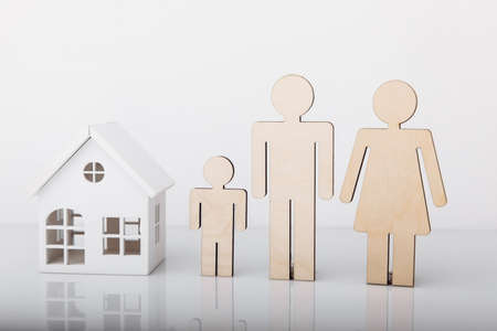 Wooden model of house and family isolated on white. Close-upの写真素材