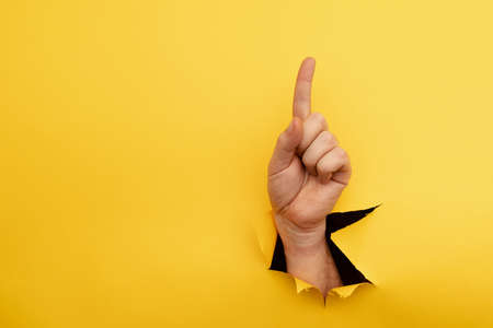 Hand forefinger indicating of the direction isolated on yellow backgroundの写真素材