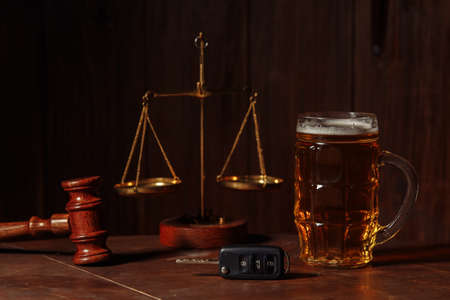 Glass of beer, car keys and wooden judge gavel in a notary office. Alcohol and law conceptの写真素材