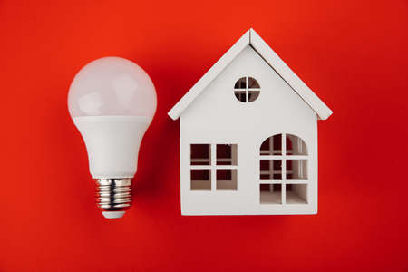 Model of house with and light bulb on the table. Power energy concept ecologyの写真素材