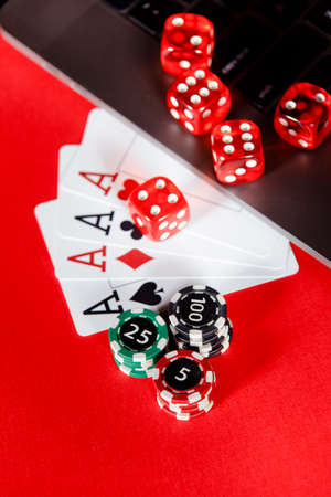 Red playing chips, dice and cards with aces close-up. Vertical image