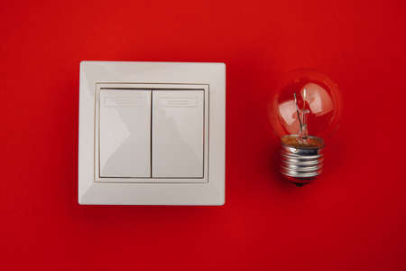 Light bulb and switch on red background