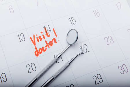 Dental tools on calendar with mark. Dental care conceptの写真素材